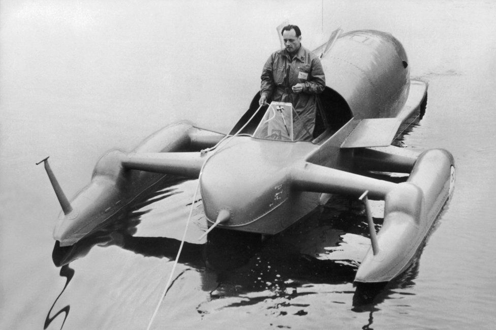 Donald Campbell standing in Bluebird's cockpit