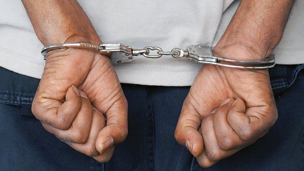 A man's hands in handcuffs