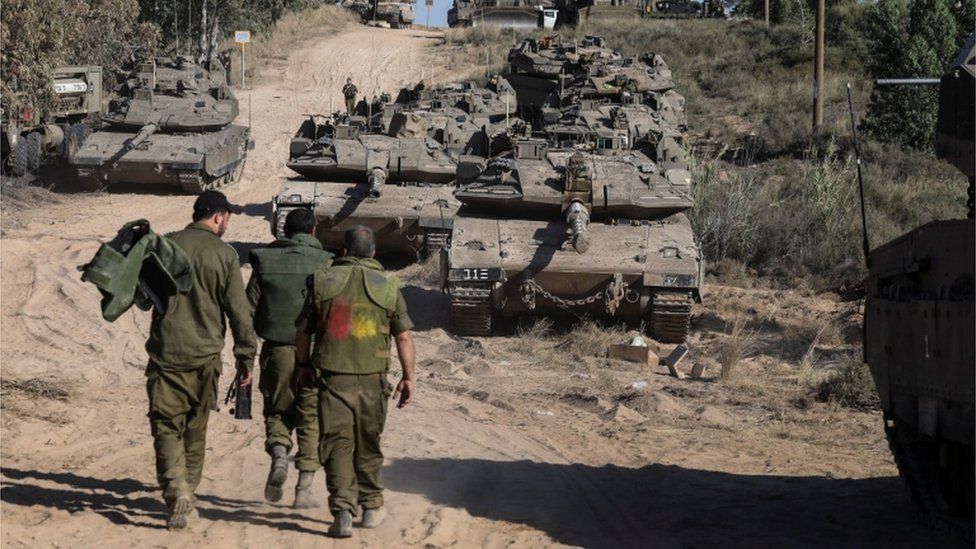 Israeli army walking near tanks