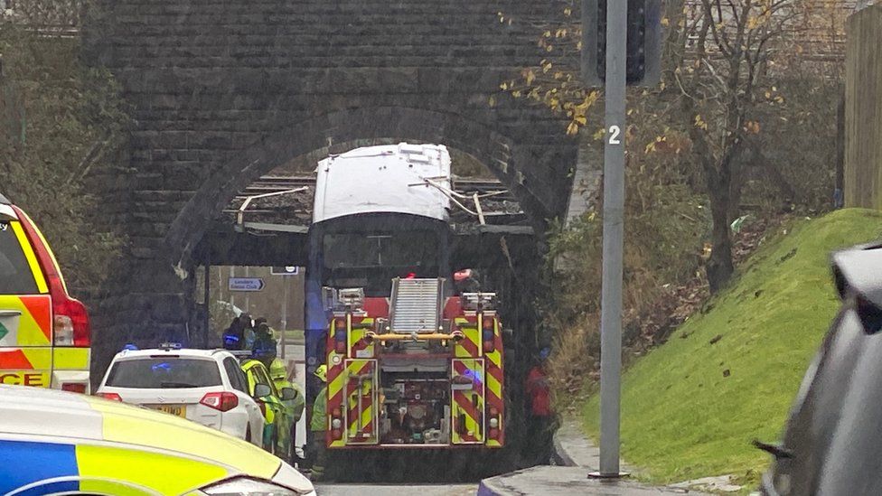A bus that has crashed into a railway bridge