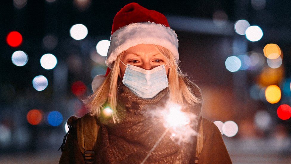 Woman wearing face mask and holding sparkler