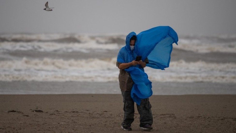A local resident as she tries to take photos ahead of the arrival of Storm Nicholas in Texas