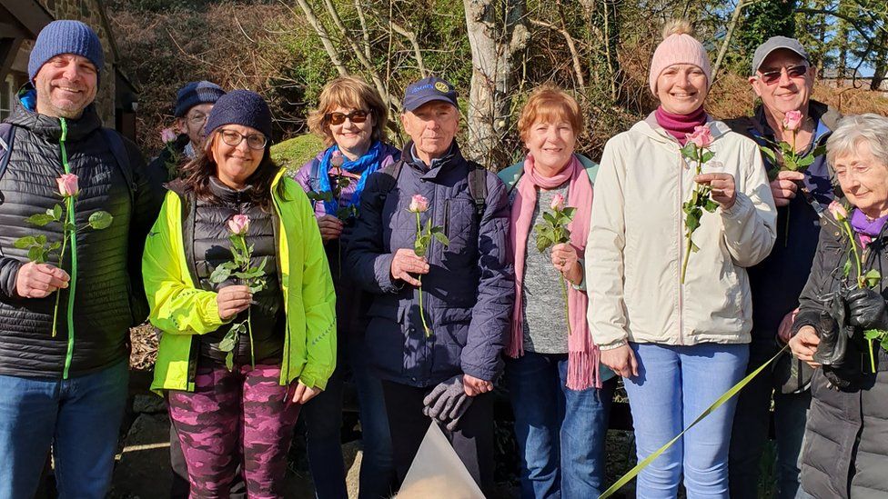 A group of walkers holding roses