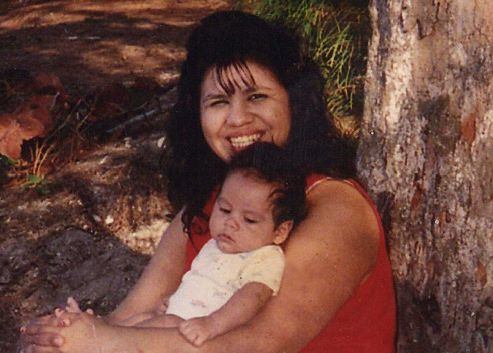 Woman leaning against tree