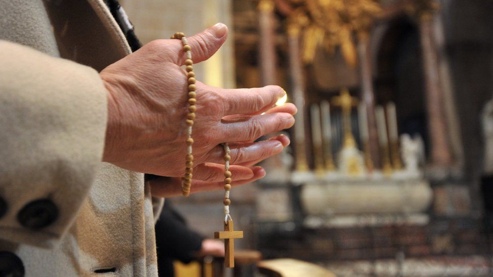 Hands holding rosary beads