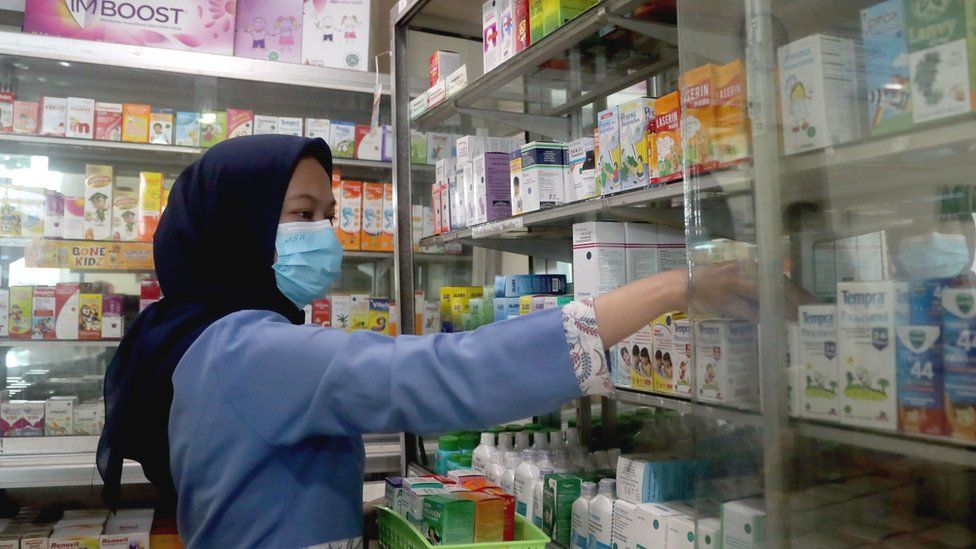 pharmacist takes medicine off shelves