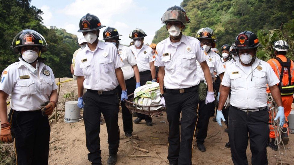 Firemen carry a body recovered from the debris in the village of El Cambray II, in Santa Catarina Pinula municipality, some 15 km east of Guatemala City, on October 4, 2015 after a landslide late Thursday struck the village