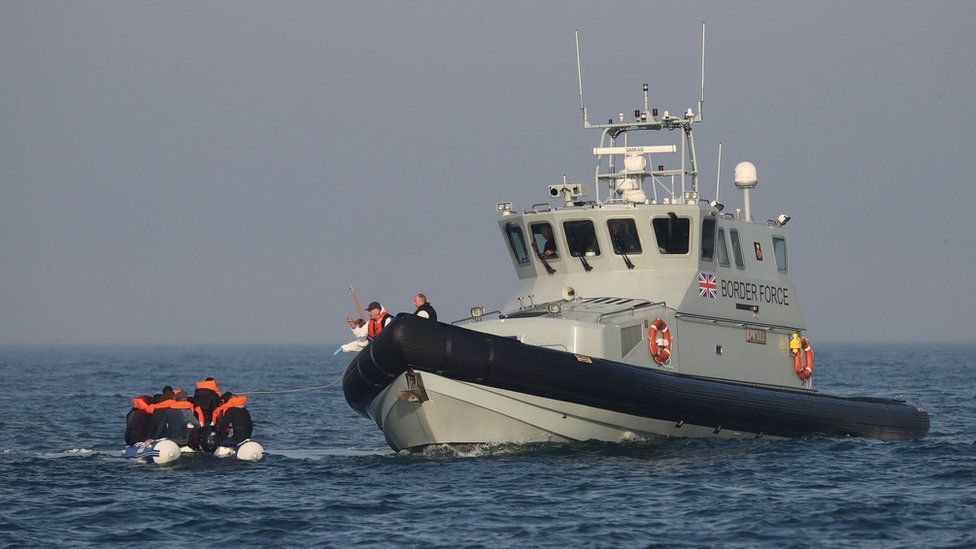 Border Force officers aboard HMC Hunter speak to group of people, thought to be migrants