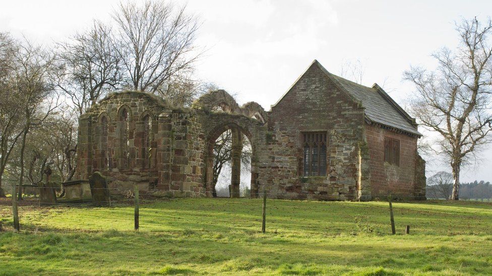 An old church next to a ruined wall