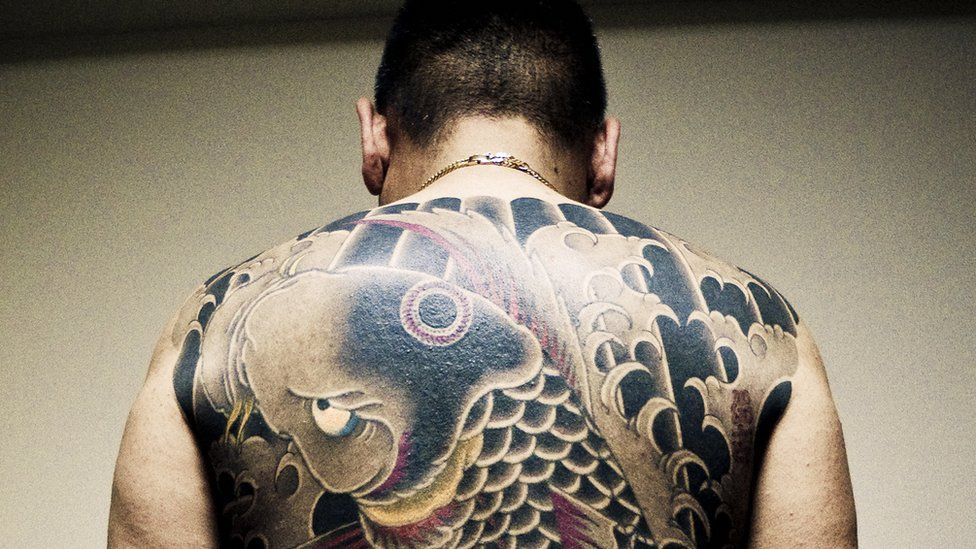 A man with tattoos on his back