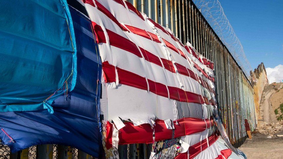 A patchwork representing a US flag hangs on the US-Mexico border in Playas de Tijuana, Baja California State, Mexico, on March 8, 2019