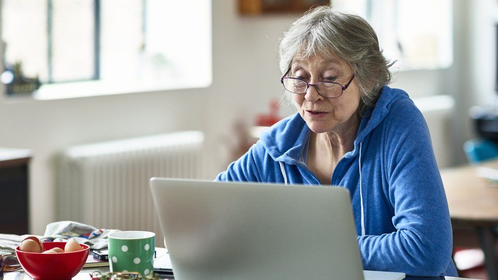 Женщина смотрит на ноутбук