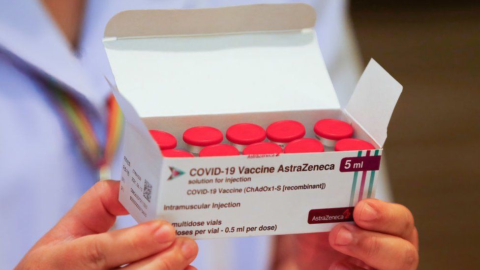 A health worker holds a box of the AstraZeneca vaccine