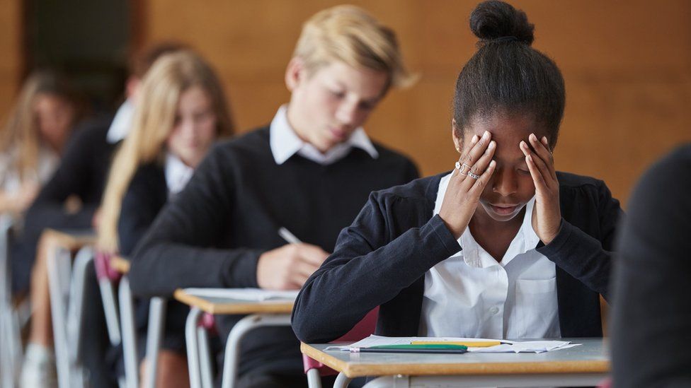 Pupil in school exams with hands up to face