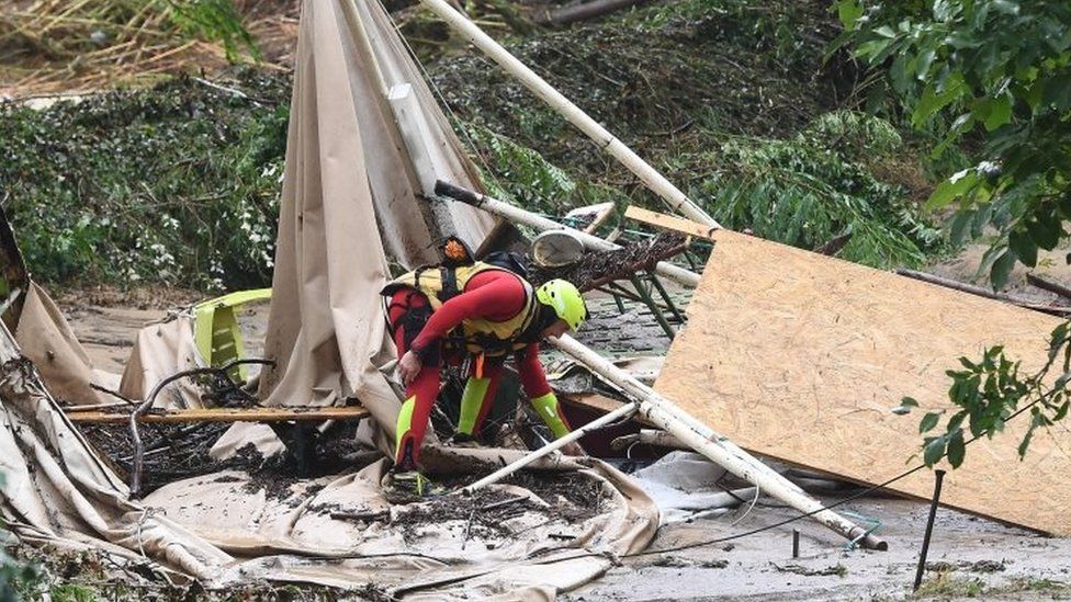 A rescuer checks damaged tents in Saint-Julien-de-Peyrolas, southern France. Photo: 9 August 2018