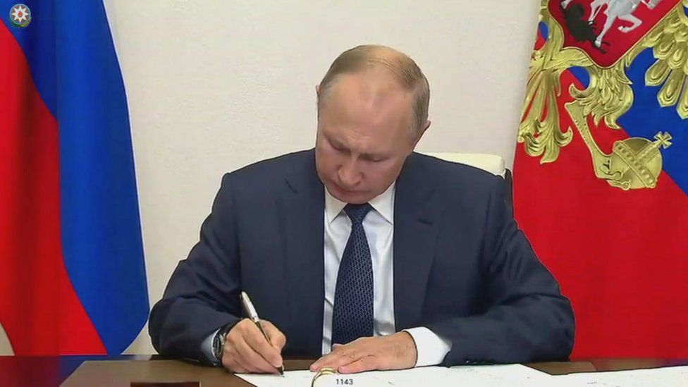 Russian President Vladimir Putin signing documents at Novo-Ogaryovo state residence, outside Moscow, Russia