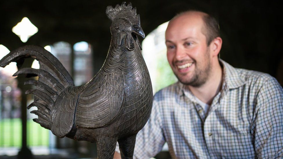 Archivist Robert Athol with a bronze statue of a cockerel
