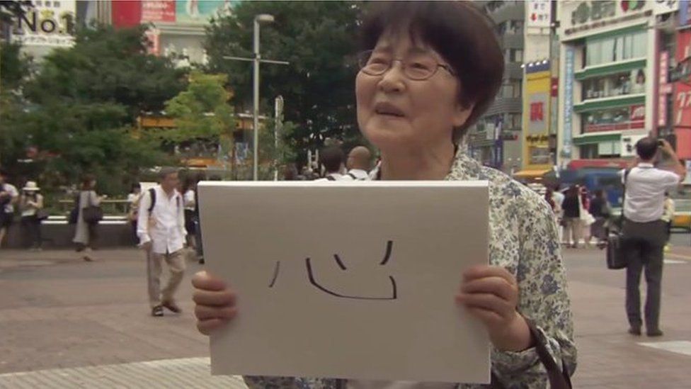 A woman holds a sign in Tokyo