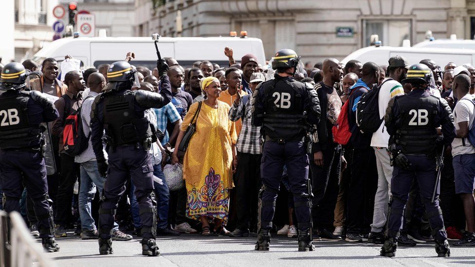 French police officers stand as undocumented migrants demonstrate at the Panthéon