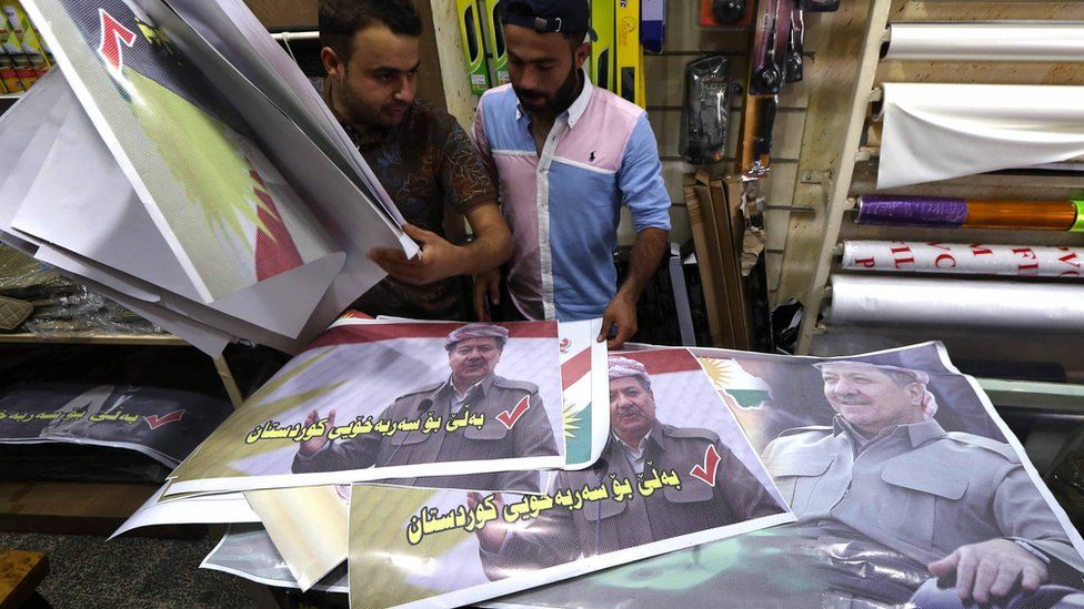 Iraqi Kurdish men look at posters bearing images of Massoud Barzani and urging people to vote in the upcoming independence referendum in Irbil (7 September 2017)