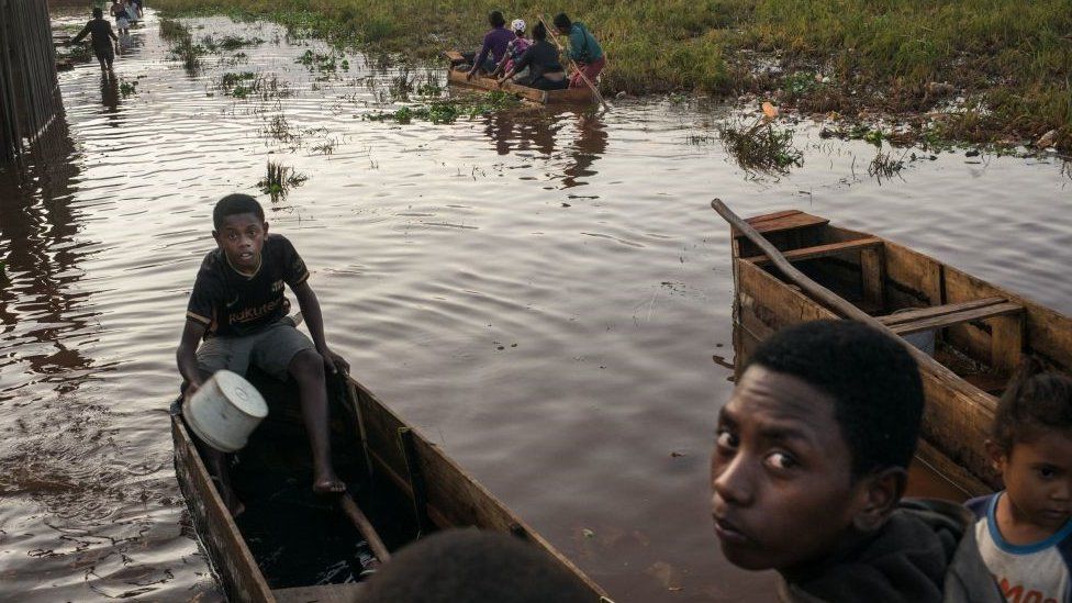 Люди на Мадагаскаре на лодке после наводнения