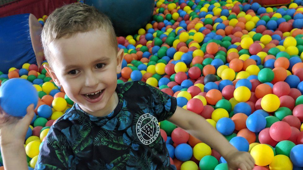 Oscar surrounded by coloured soft play balls