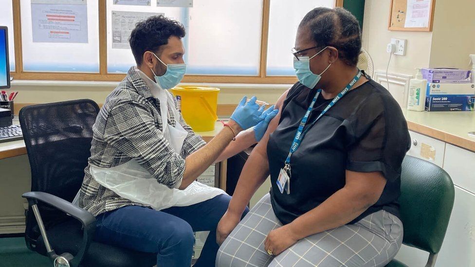 Dr Kamaldeep Tamber vaccinating a woman
