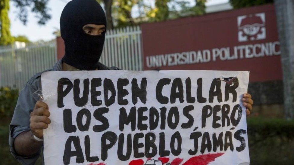 A protester holds a sign that reads: "They can silence the media but not the people" during a demonstration in front of the Polytechnic University of Nicaragua on the fifth day of protests against a social security reform in Managua, Nicaragua, 22 April 2018