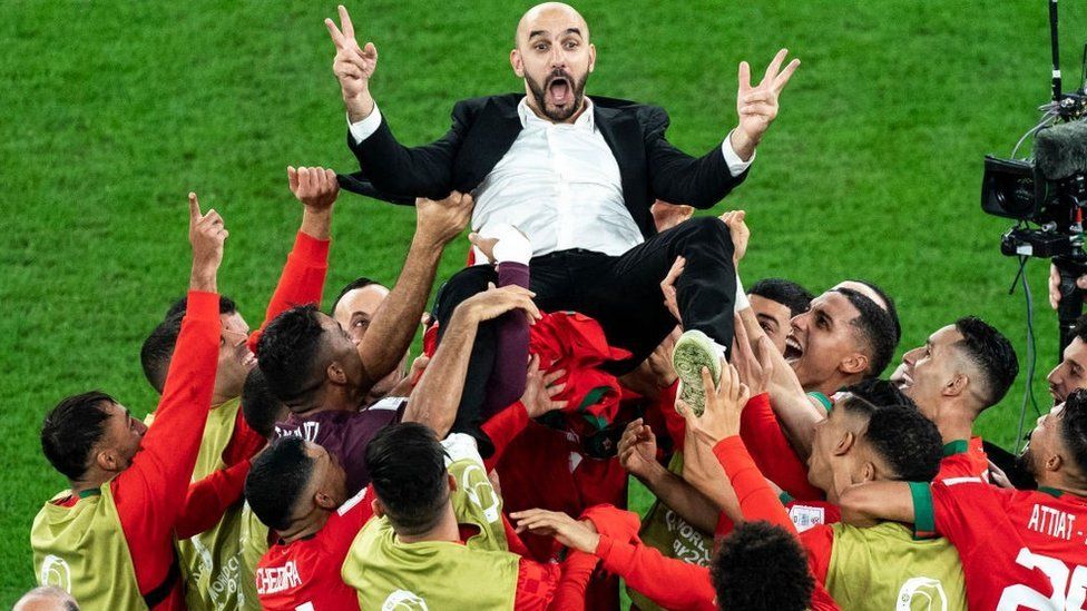 Morocco's head coach Walid Regragui is thrown in the air as Morocco players celebrate after winning the penalty shootout during a round 16 soccer game against Spain, at the Education City Stadium during the FIFA World Cup 2022, on Tuesday, Dec. 06, 2022 in Doha, Qatar