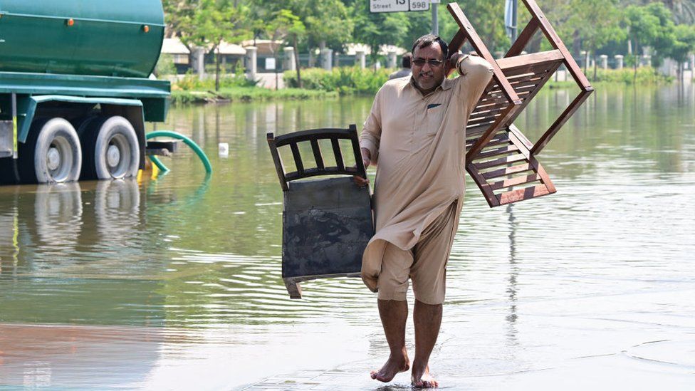 A man carries salvaged furniture in Dubai, on April 19, 2024.