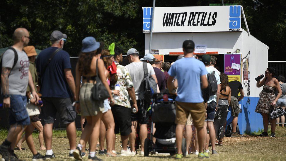 Festival-goers queue at a water refill point during day two of Glastonbury Festival