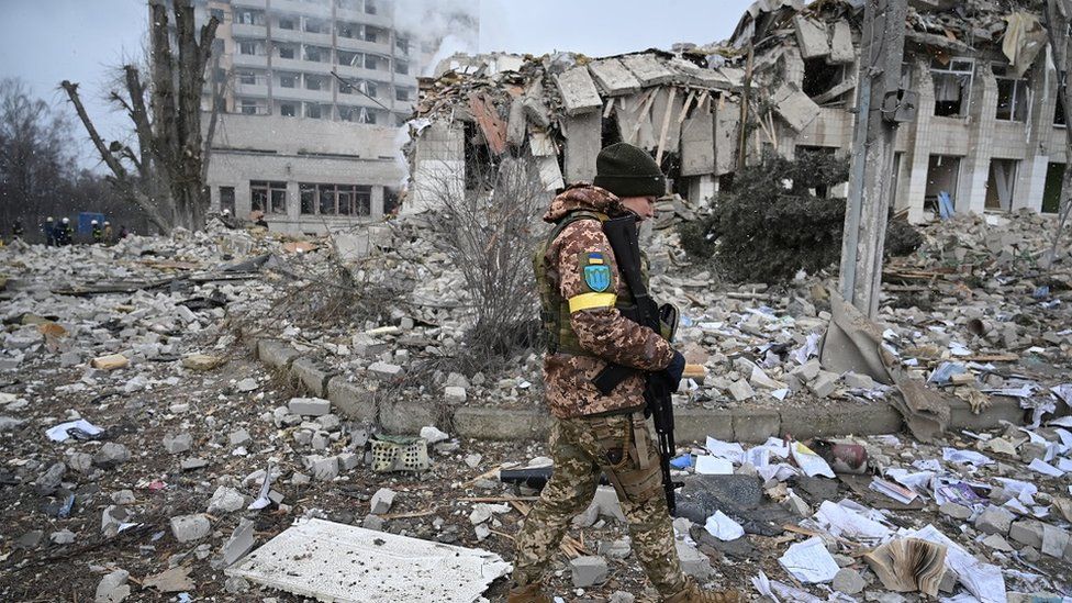 Soldiers walks by destroyed school building