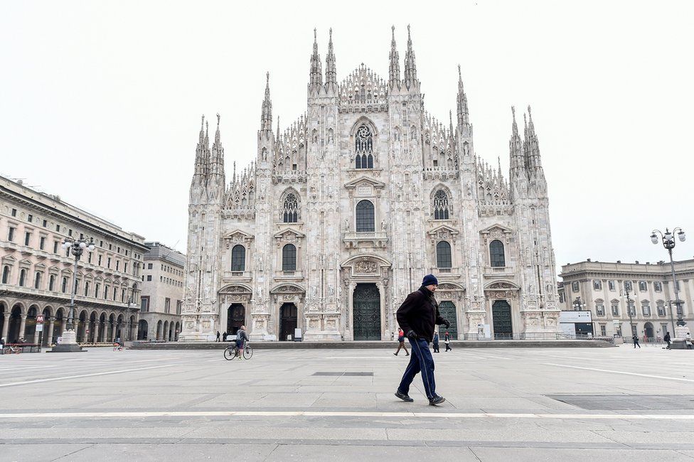 A man walks in Duomo square in Milan