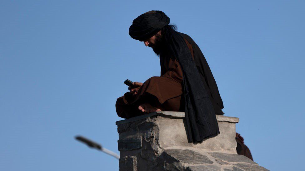 A Taliban fighter uses his phone at Wazir Akbar Khan hilltop in Kabul on August 30, 2022