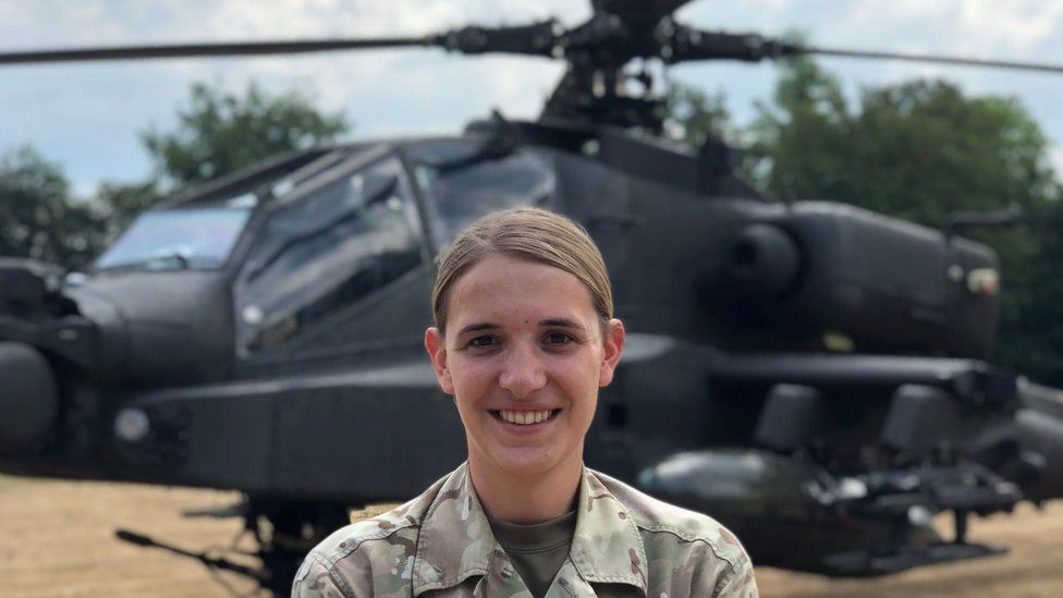 Hannah in uniform in front of a helicopter