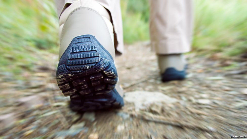 Boots walking through country terrain