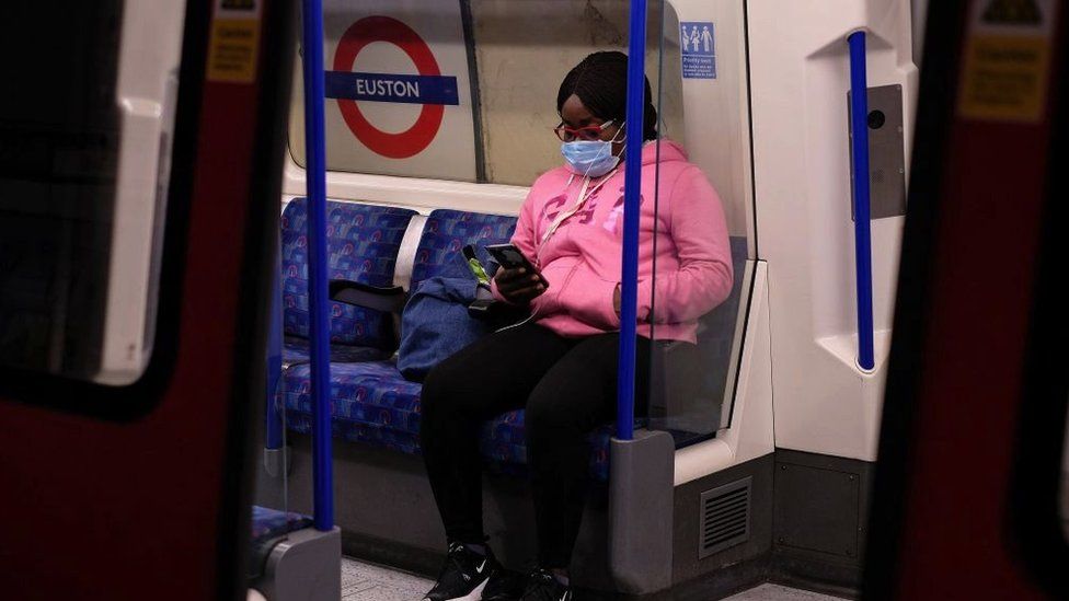 A woman wears a face covering on a tube train on 13 May, 2020
