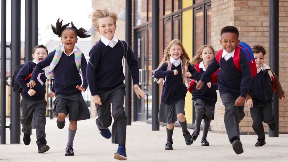 Happy kids running outside school
