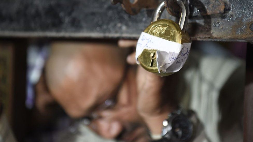 Close up of lock securing bank branch with close up of Central Bureau of Investigations officials face