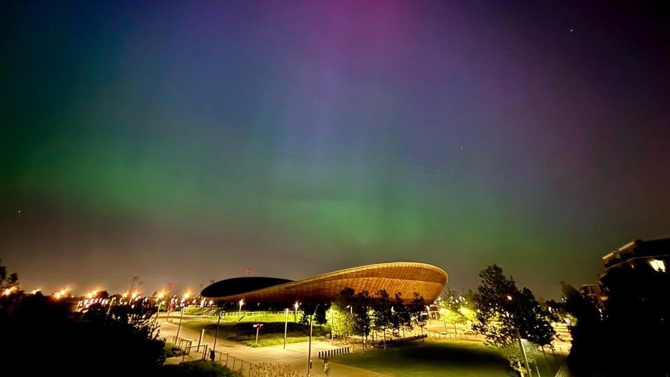 View of green, blue and pink northern lights above Stratford's Olympic Park and London Stadium