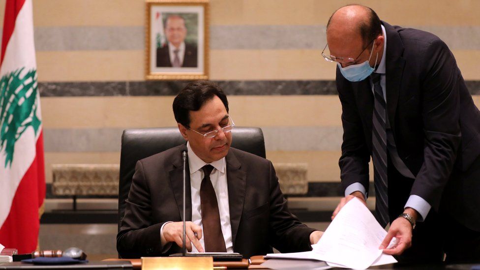 Lebanese Health Minister Hamad Hasan (R) shows a document to Prime Minister Hassan Diab (L) at a cabinet meeting on 10 August 2020