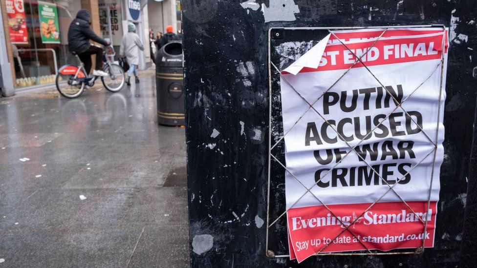 Photograph of a newspaper headline in London that reads "Putin Accused of War Crimes"