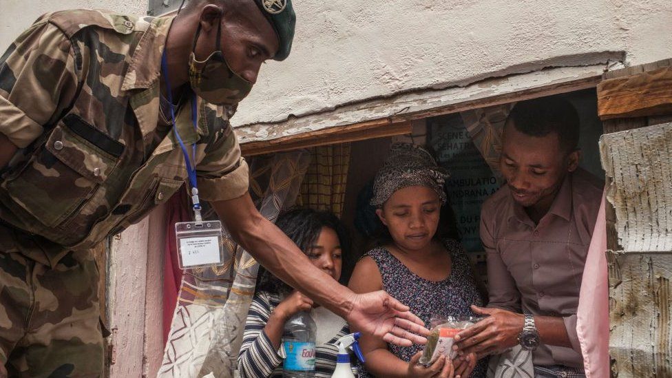 A soldier distributes masks and samples of the Covid-Organics in Antananarivo - April 2020