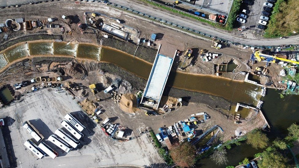 Aerial view of the River Avon flowing next to Salisbury's Central Car Park. Surrounds look like a building site.