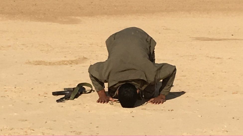 Shia fighter prays during a break in an assault on IS targets in mainly Sunni villages