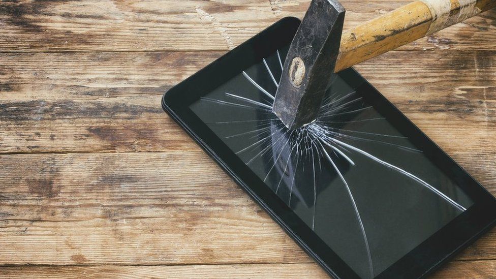 Tablet being smashed by a hammer