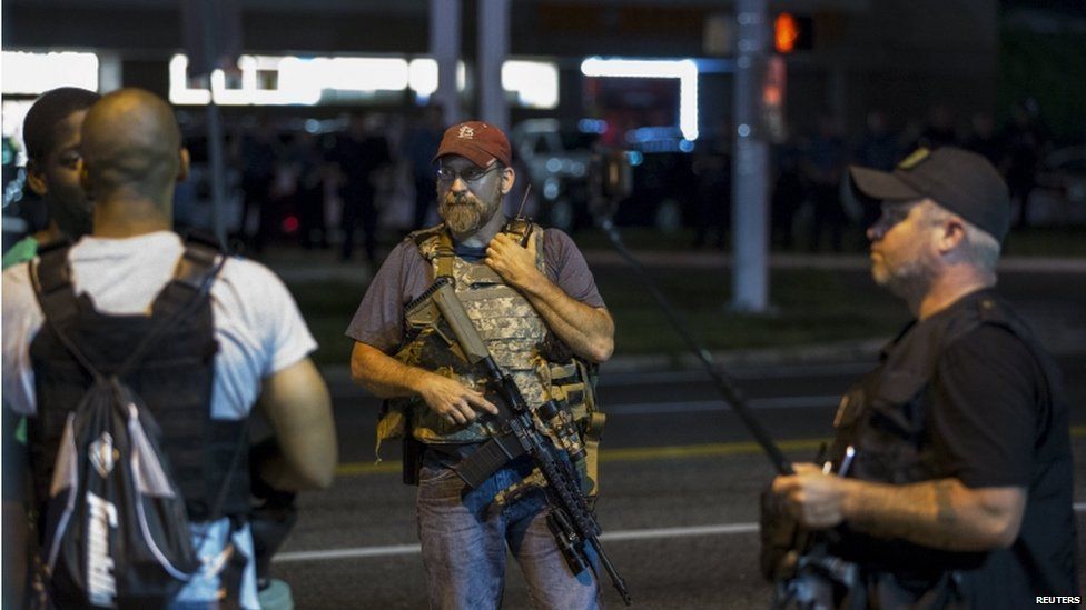 Members of the Oath Keepers walk with their personal weapons on the street during protests in Ferguson, Missouri 11 August 2015