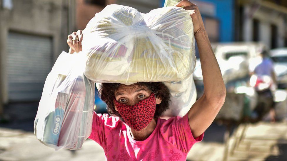 A woman, a poor resident of the Serra Aglomerado Favela, receives food supplies in Belo Horizonte