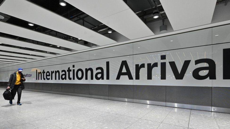 Passengers arrive with at the Terminal 5 international arrivals hall at London Heathrow Airport