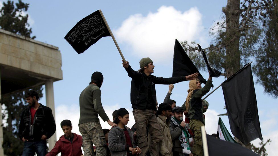 Protesters carry Nusra Front flags and shout slogans during an anti-government protest after Friday prayers in the town of Marat Numan in Idlib province, Syria, March 11, 2016